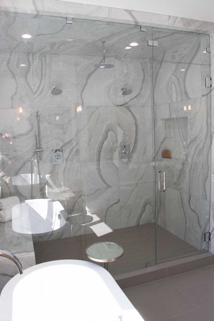 glass door shower with marble walls