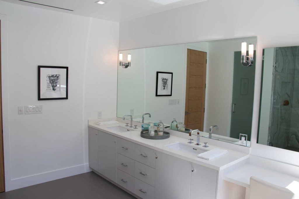 white bathroom vanity with large rectangular mirror