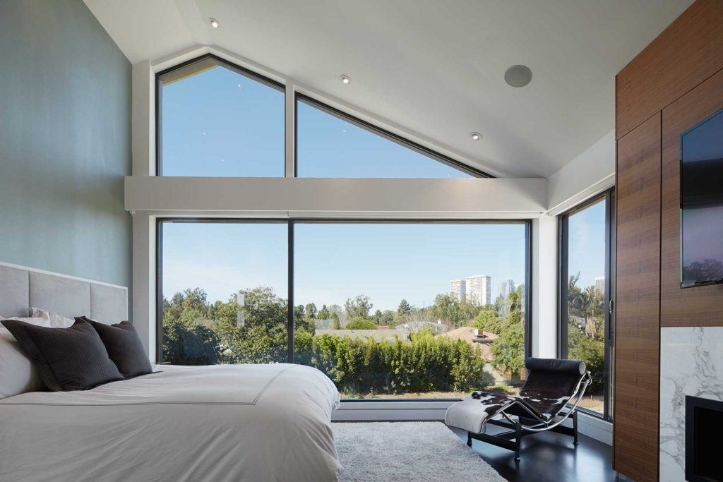 bedroom with bed chair fireplace and mounted tv