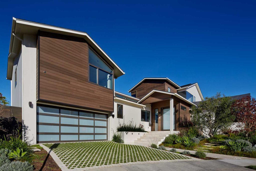 exterior of modern home with paneled garage door and driveway with circular patterned grass patches