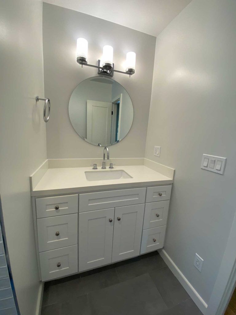 white vanity with circular mirror