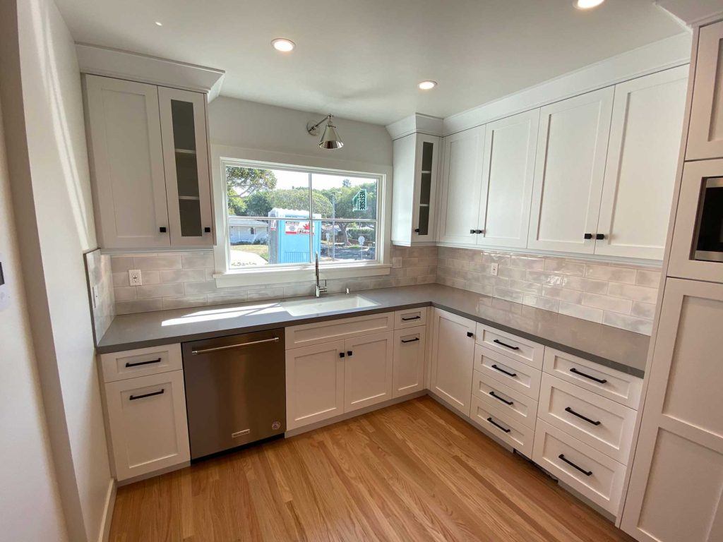 kitchen with white cabinetry featuring black handles