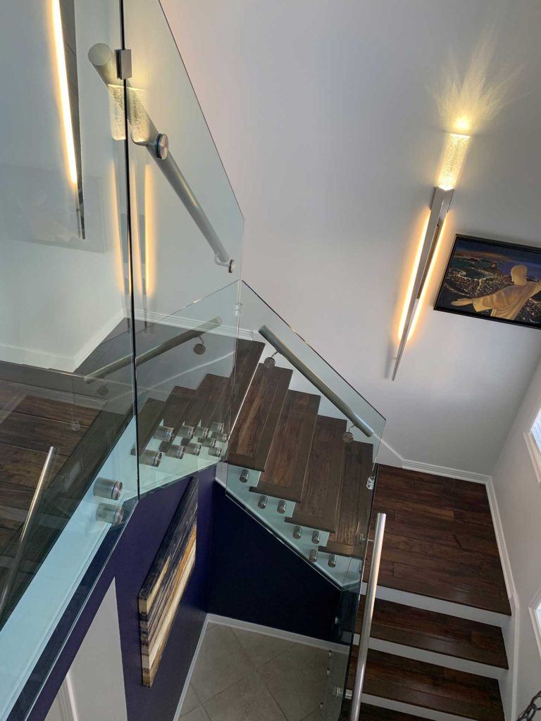 top view of staircase with black floors glass paneling and steel railings